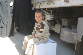 People gather to receive aid box in Mosul city